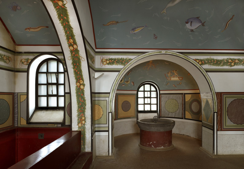 Innenaufnahme der rekonstruierten römischen Herbergsthermen im LVR-Archäologischen Park Xanten. Kennzeichnend sind die farbige Wandgestaltung mit Ornamenten sowie Abbildungen von Obst und Fischen. 