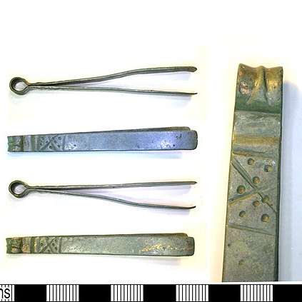 Fotografie einer römischen Pinzette aus Kupfer. Im Griffbereich verziert mit gekreuzten Linien und gestanzten Punkten. Britisches Museum, London.
